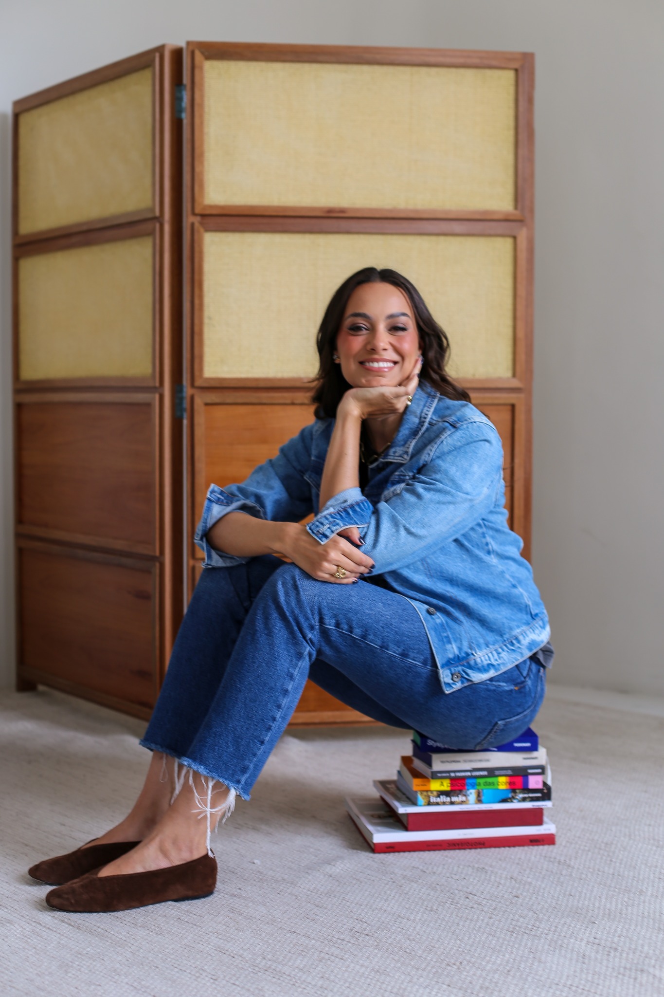 Camilla Dolle sentada sobre livros